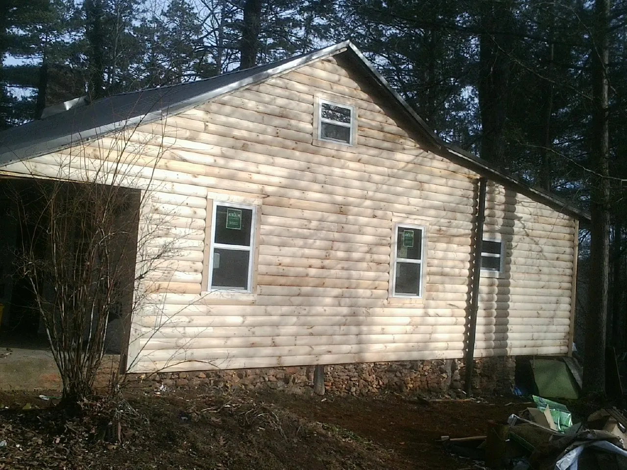 New log siding and dark metal roofing on a gable end in Charlotte