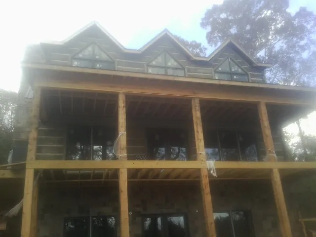 Dormers and porch framing on a large log home under construction — Roof Coating work by our crew in Charlotte